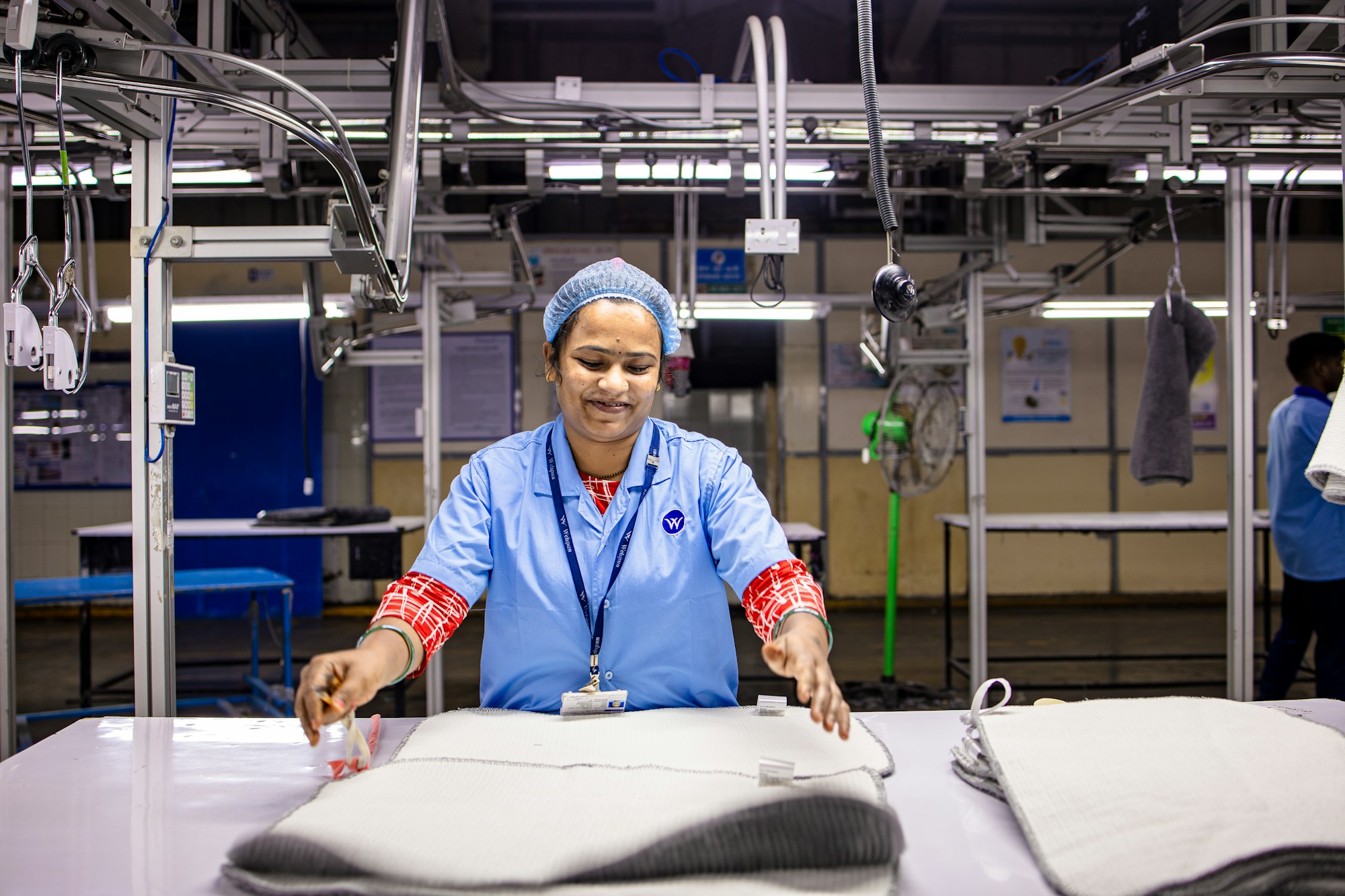 A textile production worker reviewing finished goods during manufacturing